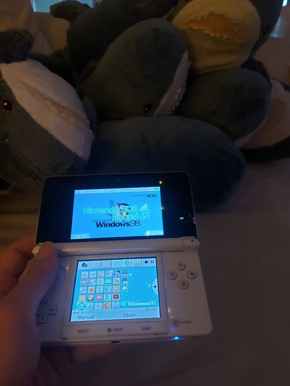 a snow white nintendo 3ds being held